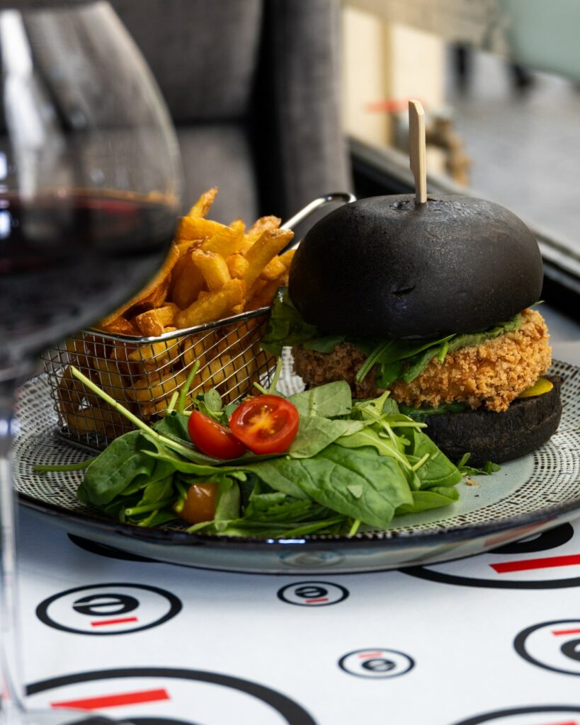 Burger au pain noir, panier de frites et salade