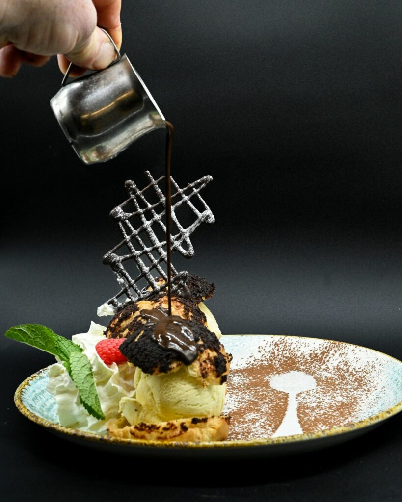 Profiteroles craquelin chocolat, sauce chocolat versée à l’assiette