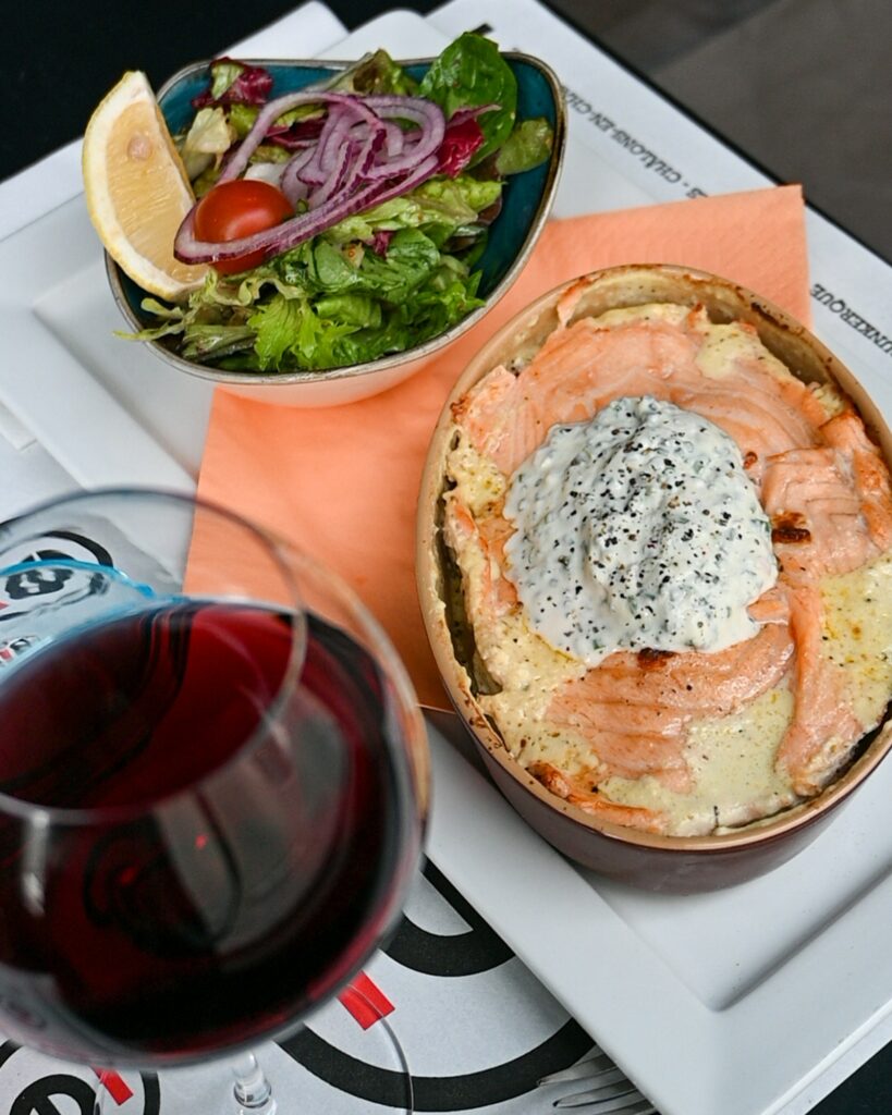 Pomme de terre norvégienne au saumon et crème ciboulette, salade et verre de vin rouge